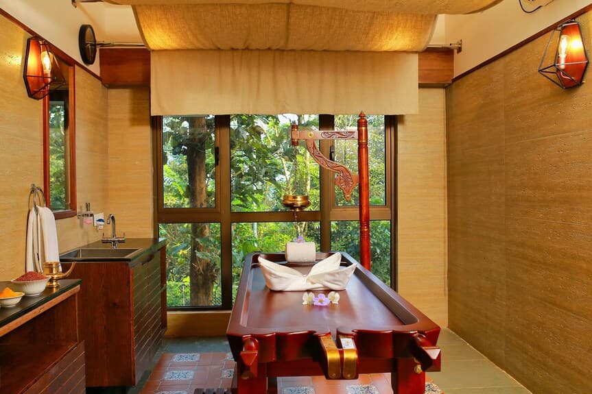 A treatment table beside a window looking out onto the forest